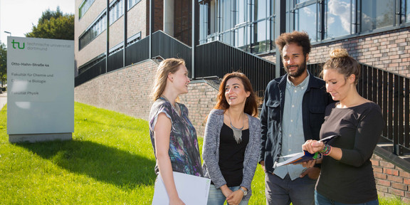 Vier Studierende stehen vor dem neu errichteten Physikgebäude.