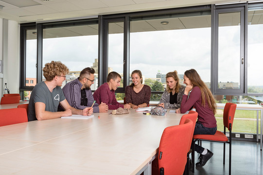 Lerngruppe Studierende sitzen mit Lernunterlagen am Tisch.